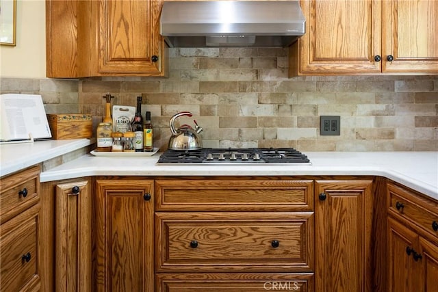 kitchen featuring tasteful backsplash, stainless steel gas cooktop, and wall chimney exhaust hood