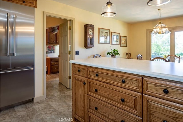 kitchen featuring stainless steel built in fridge, pendant lighting, and an inviting chandelier