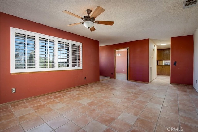 tiled spare room featuring ceiling fan and a textured ceiling