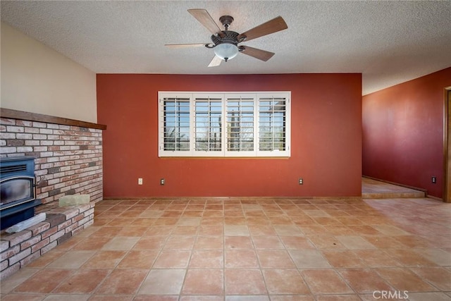 unfurnished living room featuring a wood stove, ceiling fan, and a textured ceiling