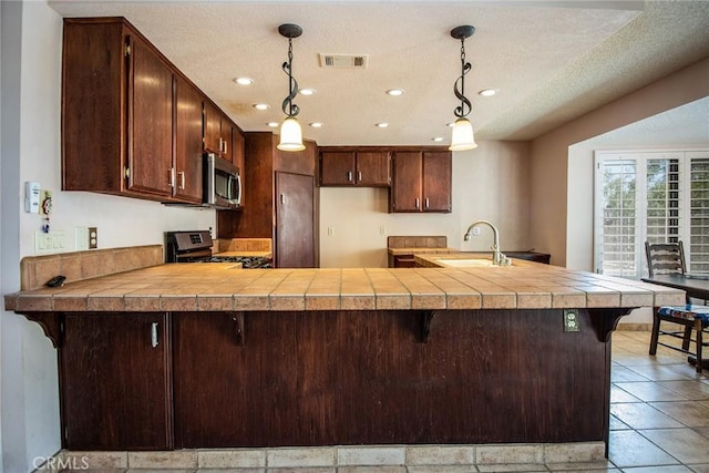 kitchen with a breakfast bar area, kitchen peninsula, and black range with gas stovetop