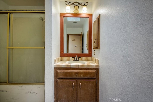 bathroom with vanity and an enclosed shower