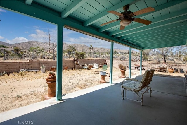 view of patio / terrace with ceiling fan and a mountain view