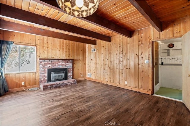 unfurnished living room featuring wood ceiling, a brick fireplace, hardwood / wood-style flooring, wooden walls, and beamed ceiling