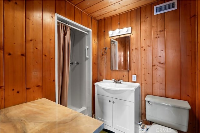 bathroom featuring toilet, vanity, wooden walls, and a shower with shower curtain