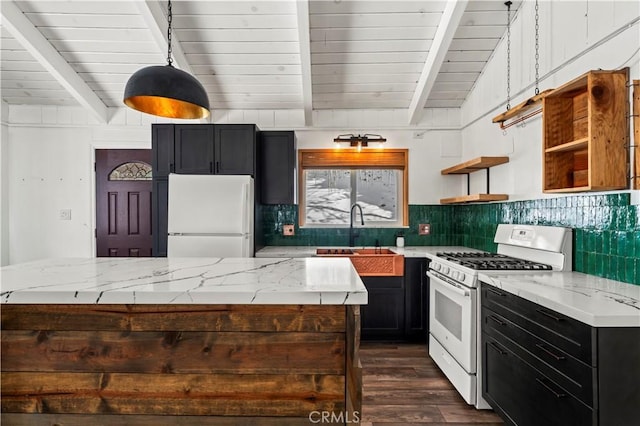 kitchen featuring beamed ceiling, white appliances, sink, and hanging light fixtures