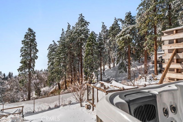 snowy yard with a hot tub