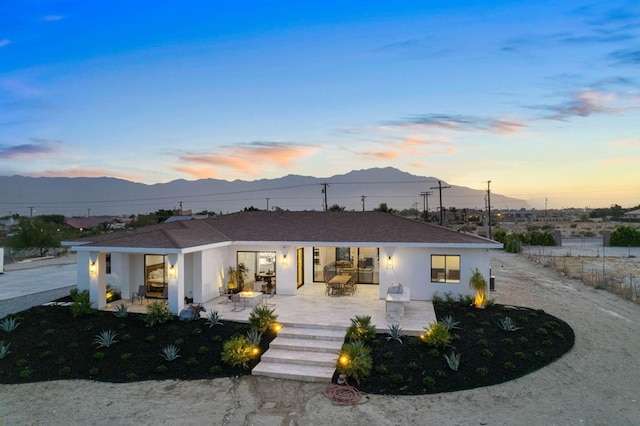 view of front of house with a patio area and a mountain view