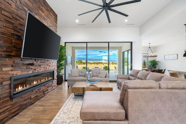 living room with hardwood / wood-style floors and ceiling fan with notable chandelier