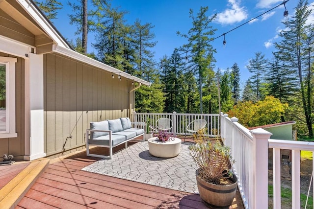 deck featuring an outdoor living space with a fire pit