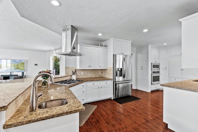 kitchen with wall chimney range hood, sink, light stone countertops, and stainless steel appliances