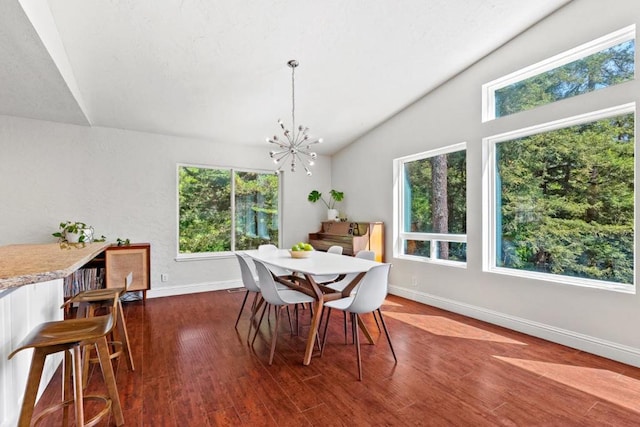 dining area with a notable chandelier, a healthy amount of sunlight, lofted ceiling, and dark wood-type flooring