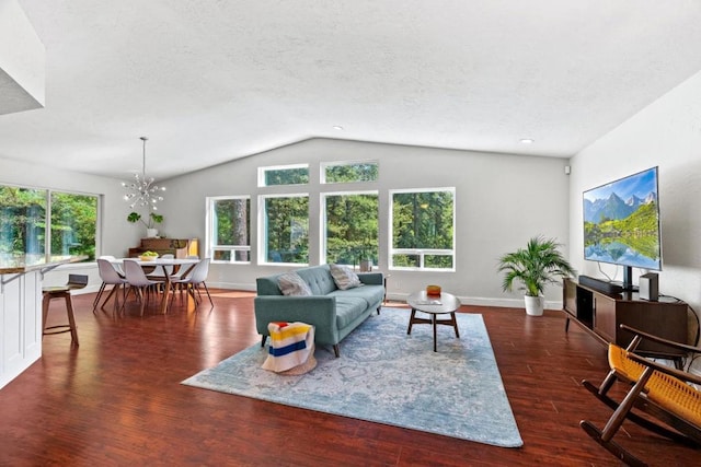 living room with dark hardwood / wood-style floors, a textured ceiling, a notable chandelier, and vaulted ceiling