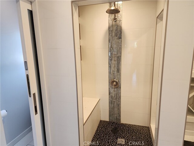 bathroom featuring a tile shower and tile flooring