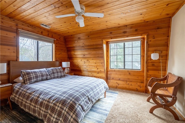 carpeted bedroom with multiple windows, wood ceiling, and ceiling fan