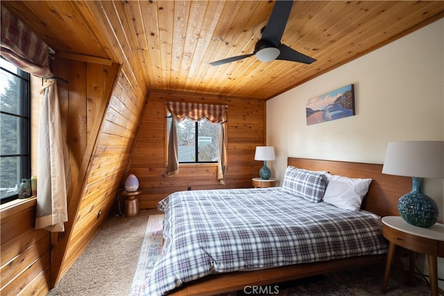 carpeted bedroom with wood walls, wooden ceiling, and ceiling fan