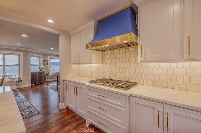 kitchen featuring light stone countertops, white cabinets, dark hardwood / wood-style flooring, and extractor fan