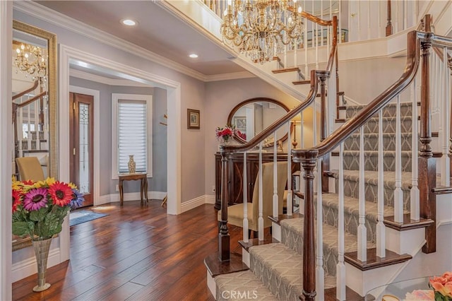 entrance foyer featuring dark hardwood / wood-style floors, crown molding, and a notable chandelier