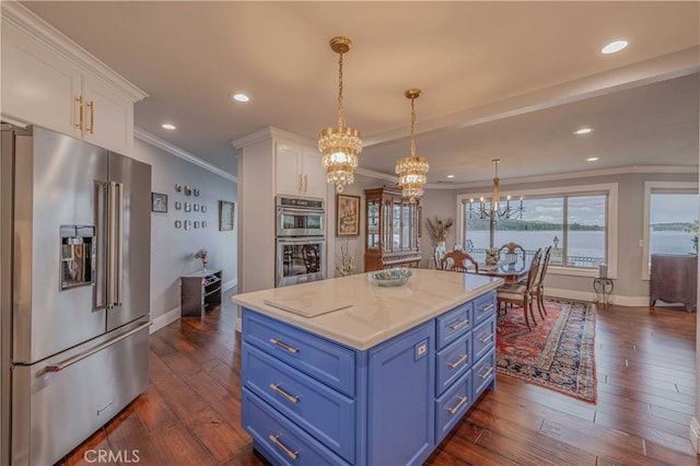 kitchen with pendant lighting, appliances with stainless steel finishes, white cabinetry, a water view, and blue cabinets