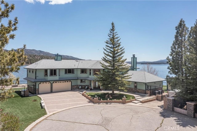 view of front of house featuring a water and mountain view and a garage