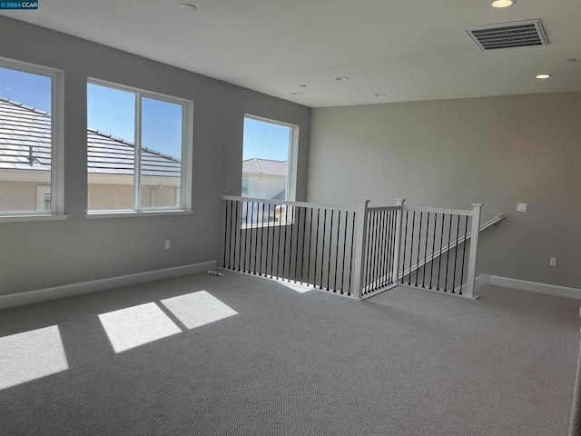 carpeted empty room with plenty of natural light