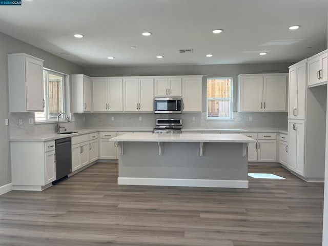 kitchen featuring a wealth of natural light, white cabinetry, and appliances with stainless steel finishes