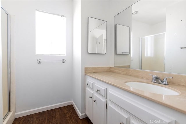 bathroom featuring hardwood / wood-style flooring, walk in shower, and vanity