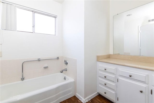 bathroom with vanity, wood-type flooring, and a bathing tub