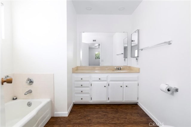 bathroom with ceiling fan, vanity, a tub, and hardwood / wood-style floors