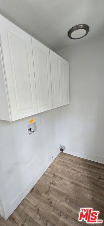 laundry area featuring hardwood / wood-style floors, hookup for a washing machine, and cabinets