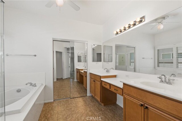 bathroom featuring tile patterned floors, vanity, ceiling fan, and a tub to relax in