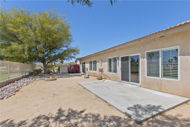 rear view of house featuring an outdoor fire pit and a patio area