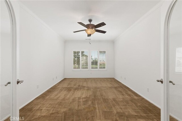 empty room with carpet, ceiling fan, and crown molding