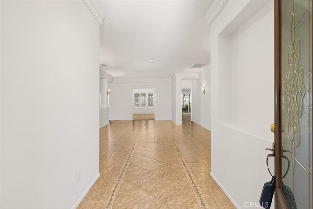 tiled entryway featuring crown molding