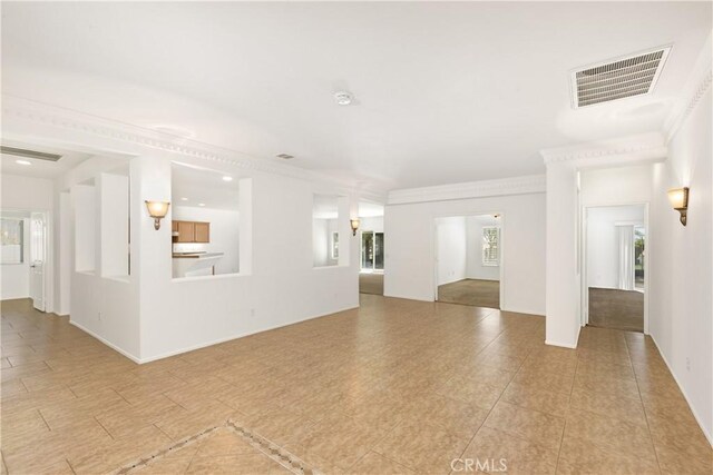 unfurnished living room featuring crown molding