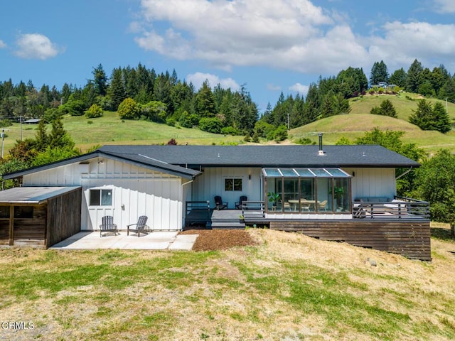 back of property featuring a yard, a patio area, and a wooden deck