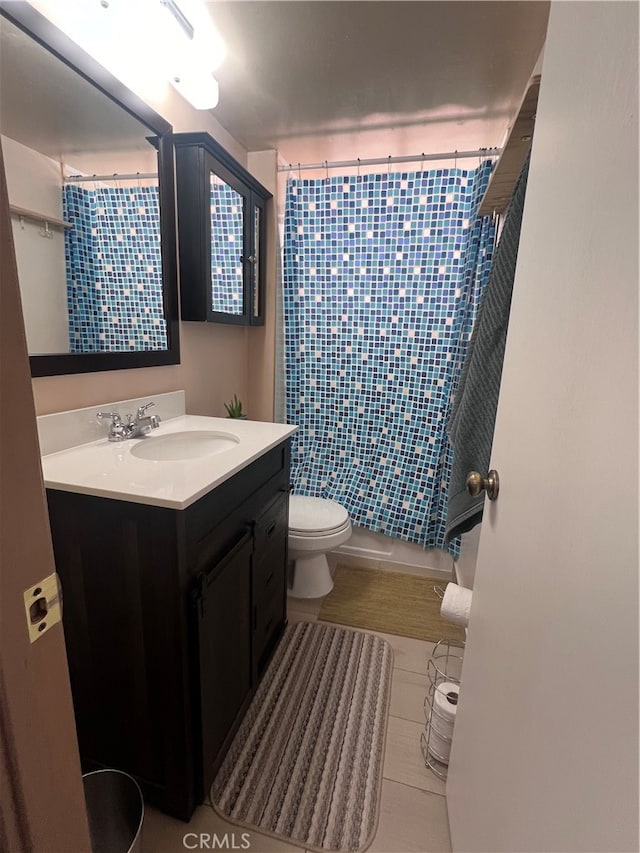 bathroom featuring tile patterned flooring, toilet, and vanity