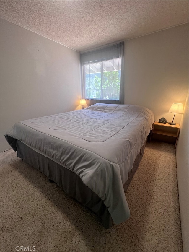 carpeted bedroom featuring a textured ceiling