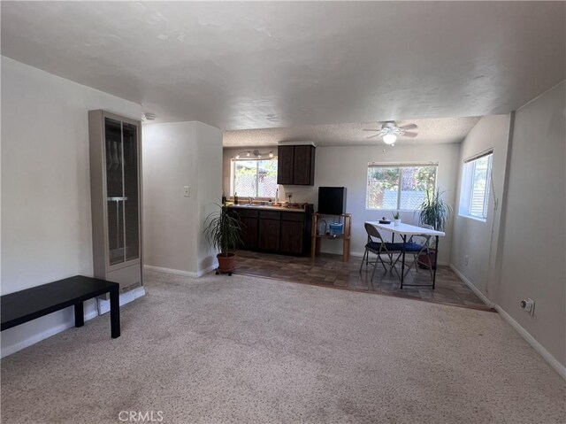 living room with a textured ceiling, carpet floors, and ceiling fan