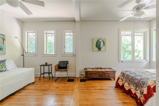 bedroom featuring multiple windows, ceiling fan, and light hardwood / wood-style flooring