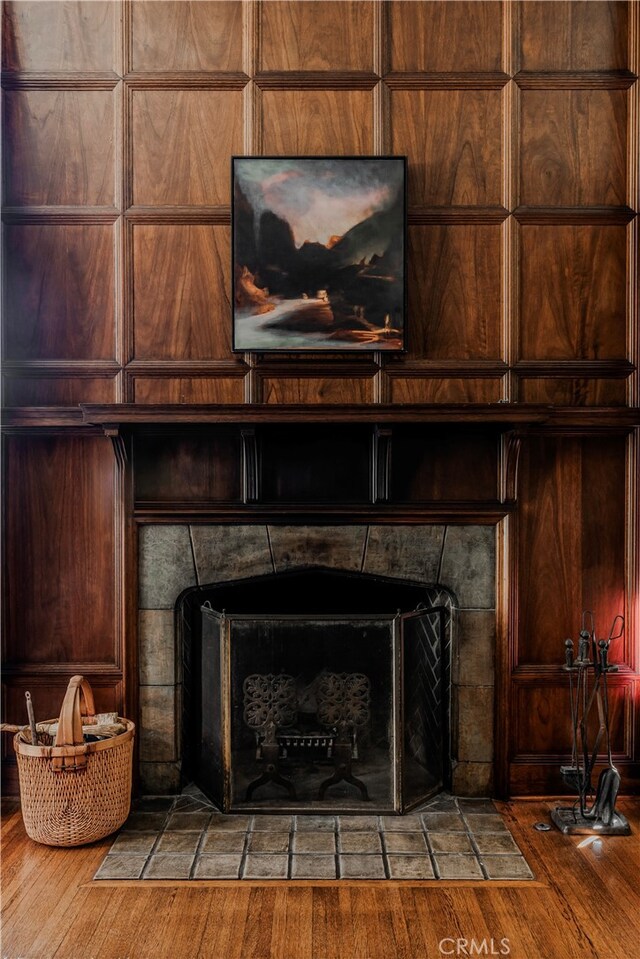 interior details with a fireplace, hardwood / wood-style floors, and wooden walls