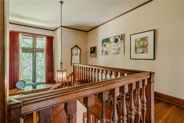 staircase featuring crown molding and hardwood / wood-style floors