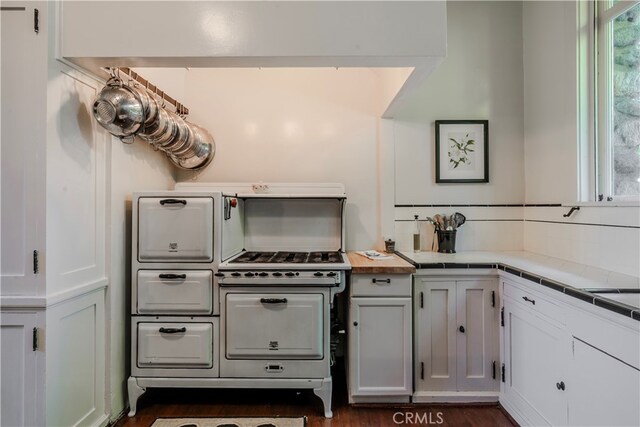 kitchen with tile countertops, dark hardwood / wood-style floors, and white cabinetry