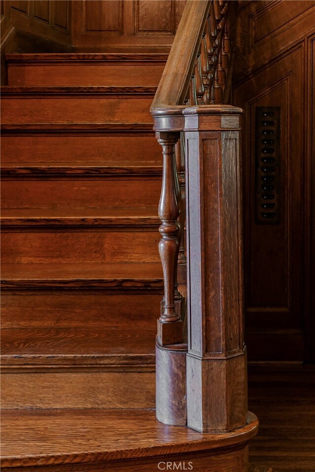 stairs featuring hardwood / wood-style flooring and wood walls