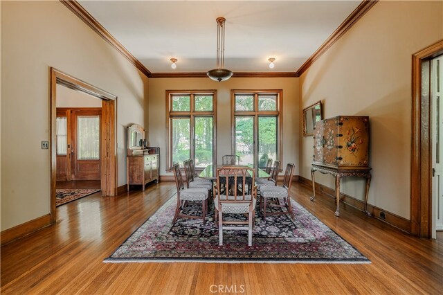 dining area featuring wood-type flooring and crown molding