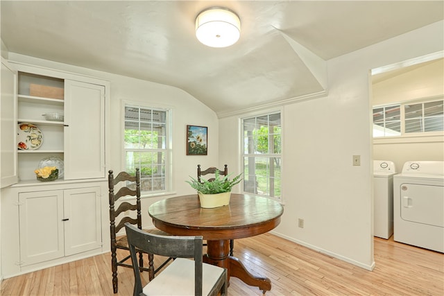 dining area with built in shelves, independent washer and dryer, light wood-type flooring, and lofted ceiling