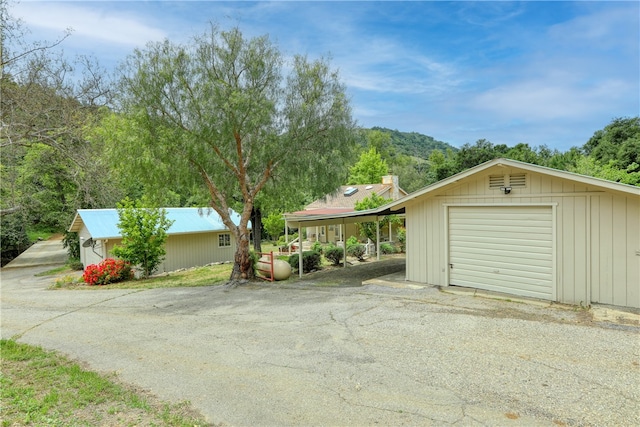 view of front of house featuring a carport, a garage, and an outdoor structure