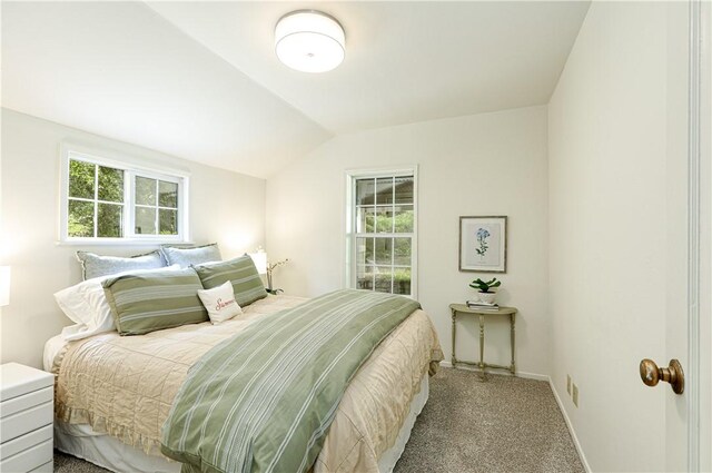 carpeted bedroom featuring lofted ceiling and baseboards