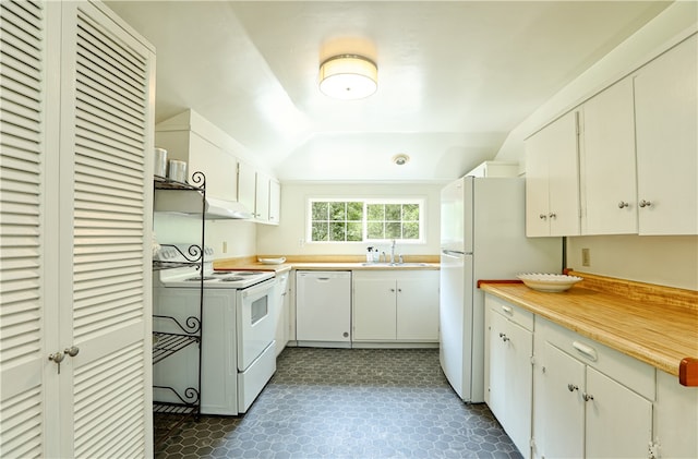 kitchen with sink, white cabinetry, dark tile flooring, and white appliances