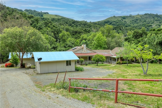 exterior space featuring a front yard, an outdoor structure, and a mountain view